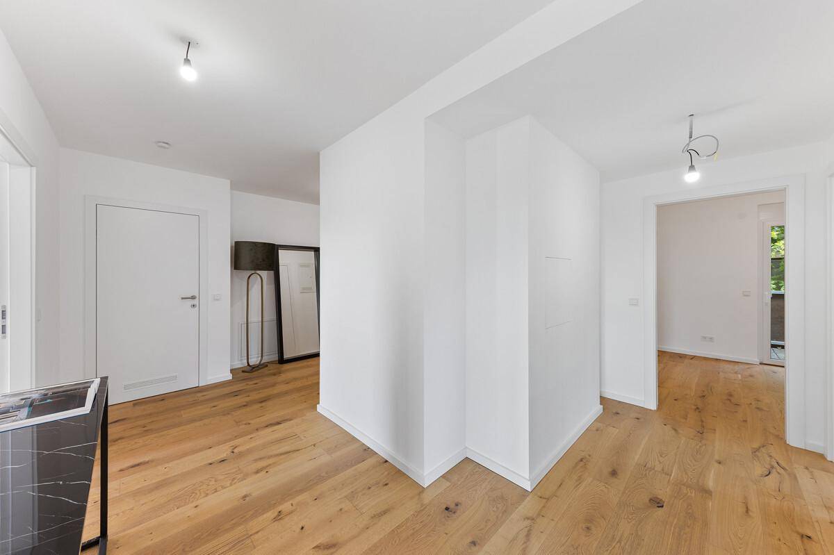 Heller Flurbereich mit Holzboden und Zugang zu verschiedenen Zimmern der Wohnung.