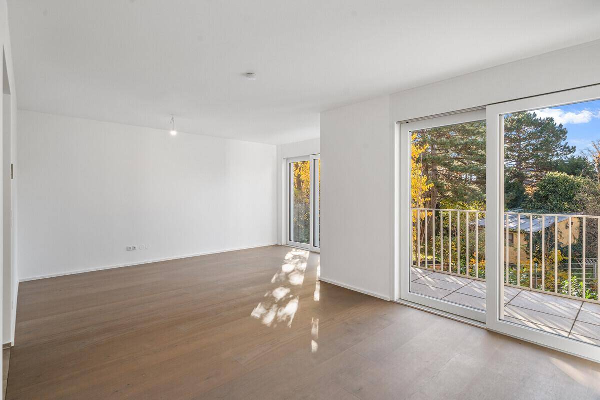 Lichtdurchfluteter Wohnbereich mit modernem Holzboden und direktem Zugang zum Außenbalkon.