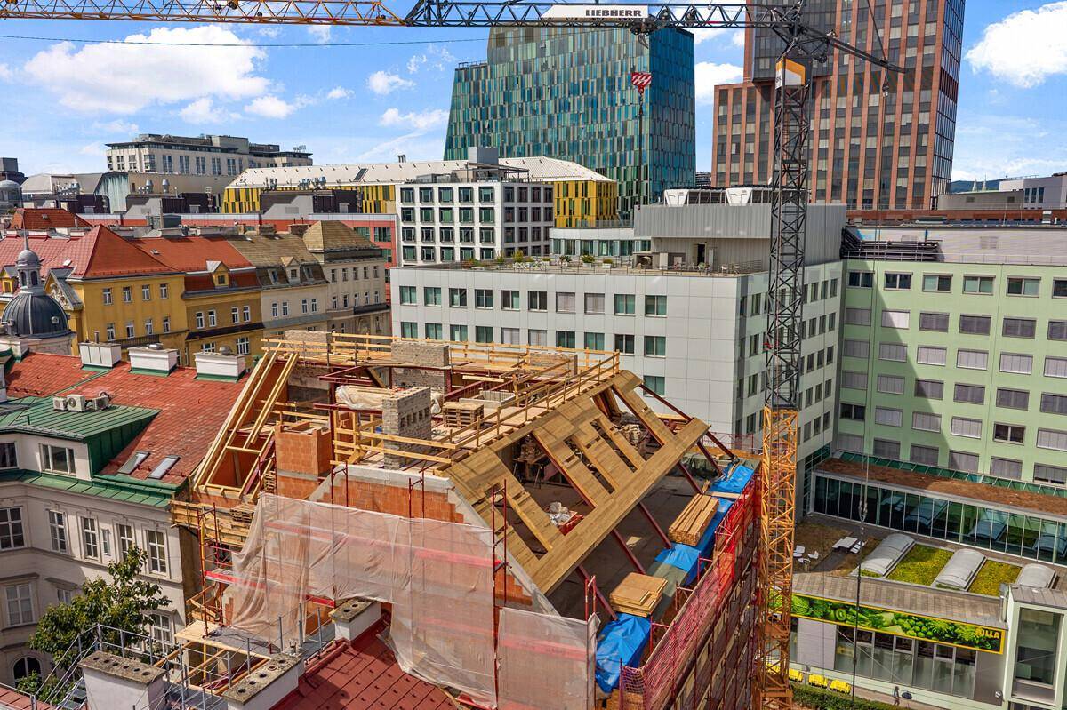 Dachausbau in der Bauphase mit Blick auf moderne Gebäude und die Stadt.