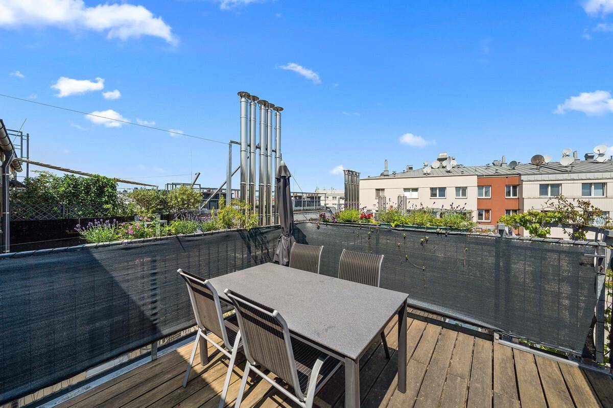 Essbereich auf der Dachterrasse mit Blick auf die umliegenden Gebäude.