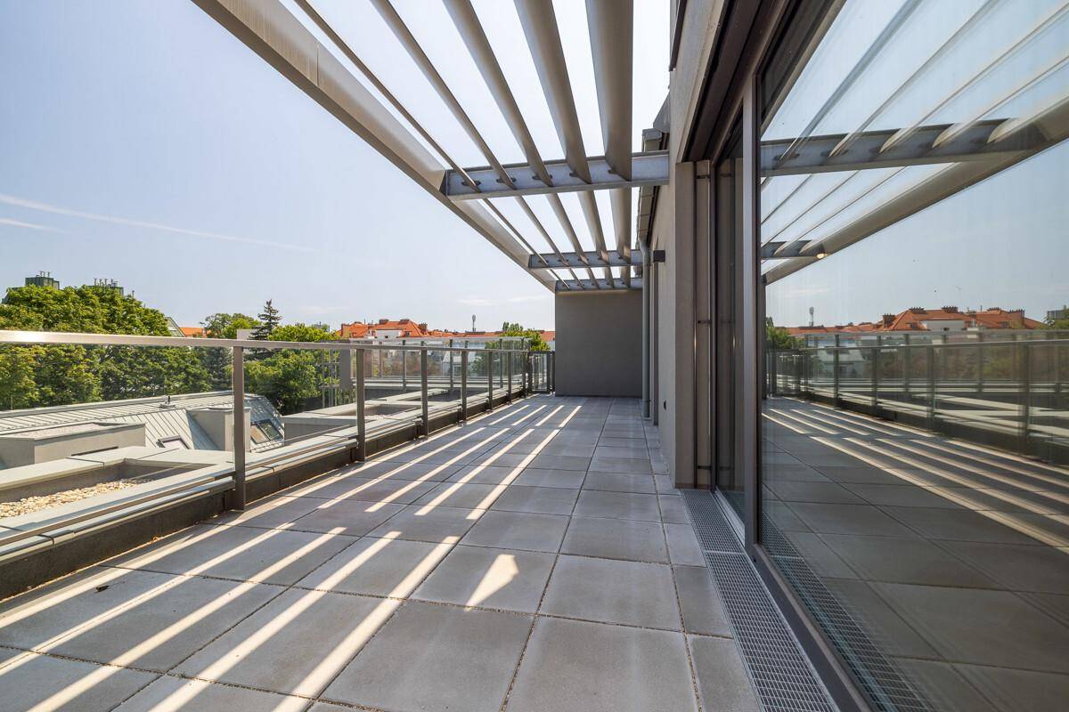 Geräumige Terrasse mit moderner Überdachung und weitem Blick über die Dächer der Stadt.