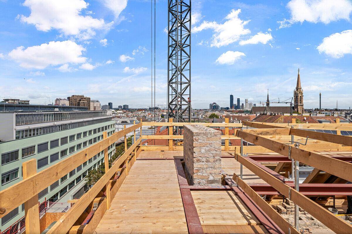 Baustelle auf dem Dach mit Holzgeländer und Panoramablick auf die Stadtkulisse.