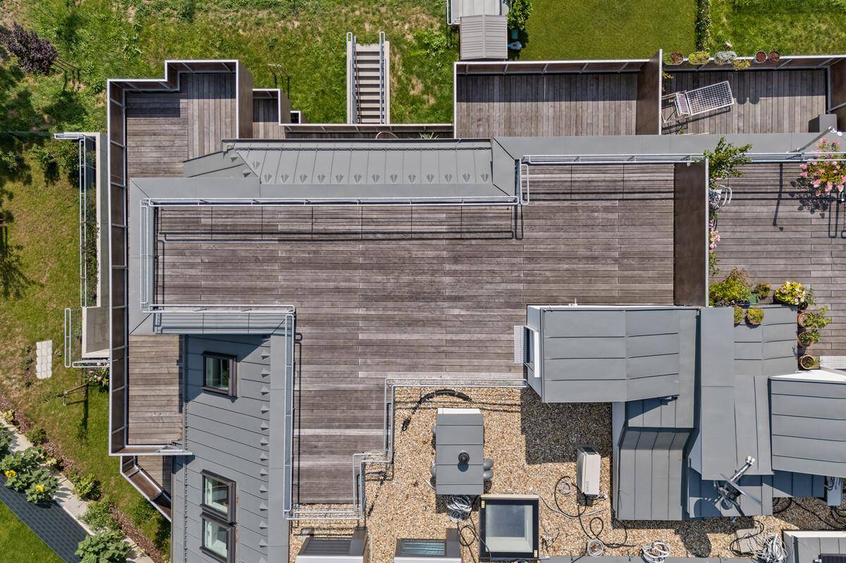 Draufsicht auf die weitläufigen Dachterrassenbereiche eines modernen Wohnkomplexes.