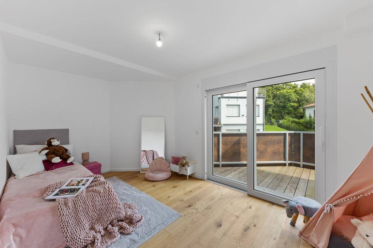 Kinderzimmer mit Holzboden, Spielzelt und direktem Zugang zu einem Balkon.