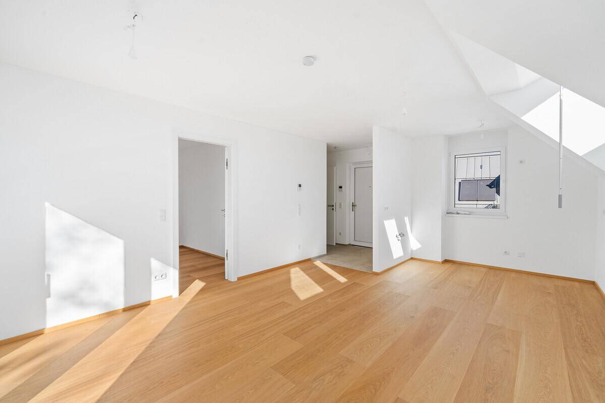 Heller Flur mit Holzboden und natürlichem Lichteinfall durch ein Fenster.