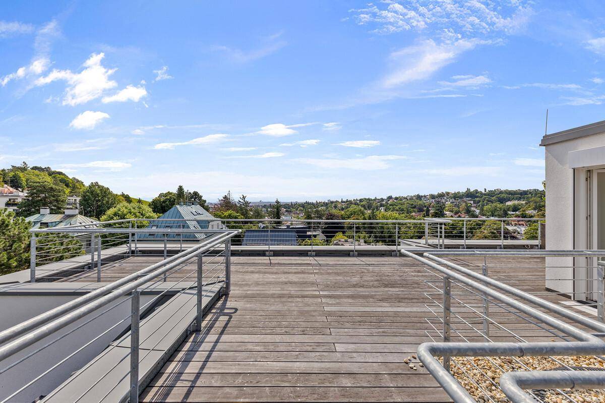 Weitläufige Dachterrasse mit Holzboden und Panoramablick auf die umliegende Landschaft.