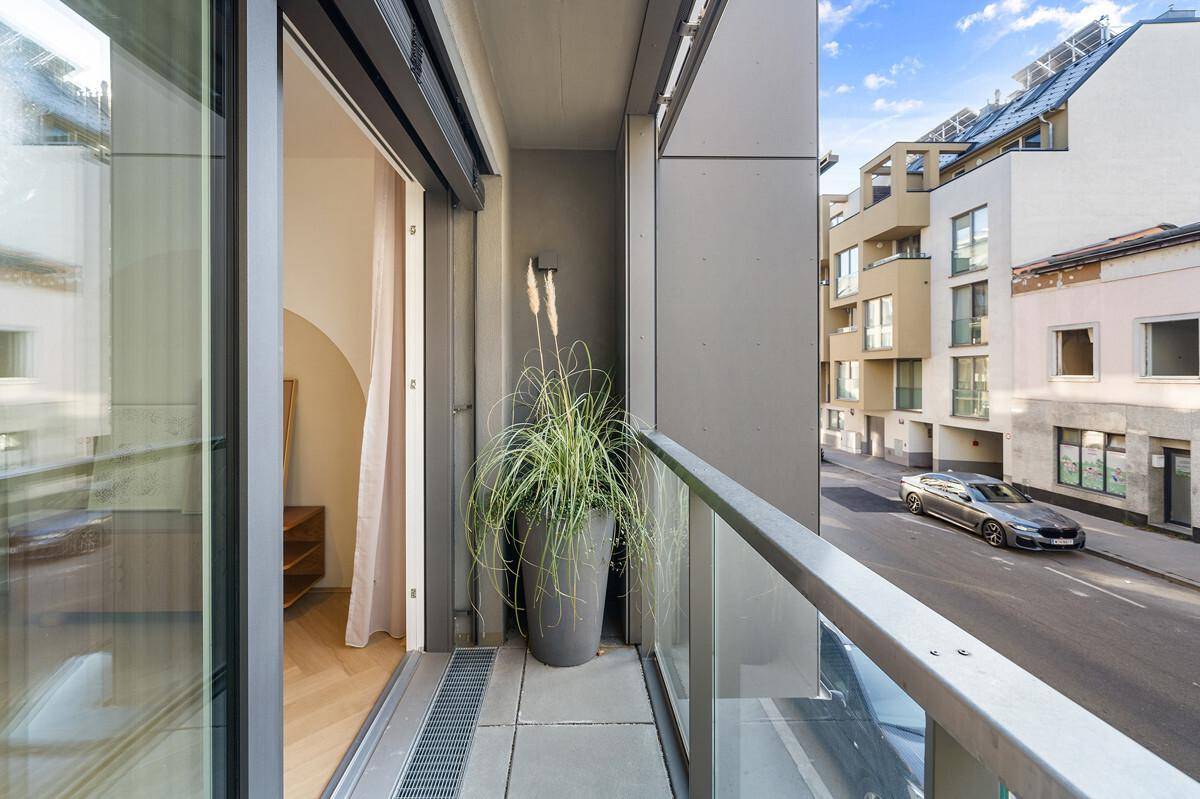 Kleiner Balkon mit Blick auf die Straße und umliegende Gebäude.