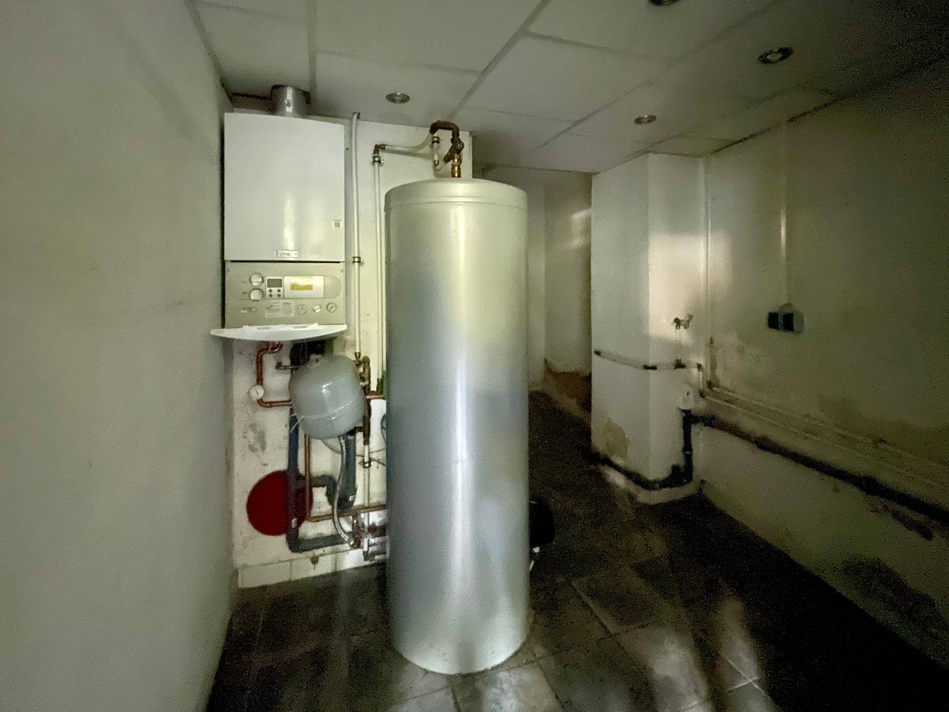 Technikraum mit Warmwasserspeicher und Heizungsanlage, funktional und gut zugänglich.