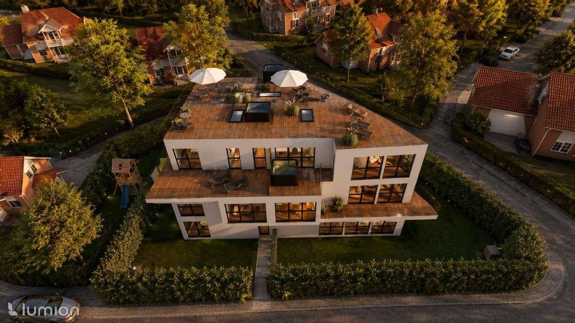 Vogelperspektive der modernen Wohnanlage mit großzügiger Dachterrasse und umliegendem Gartenbereich.