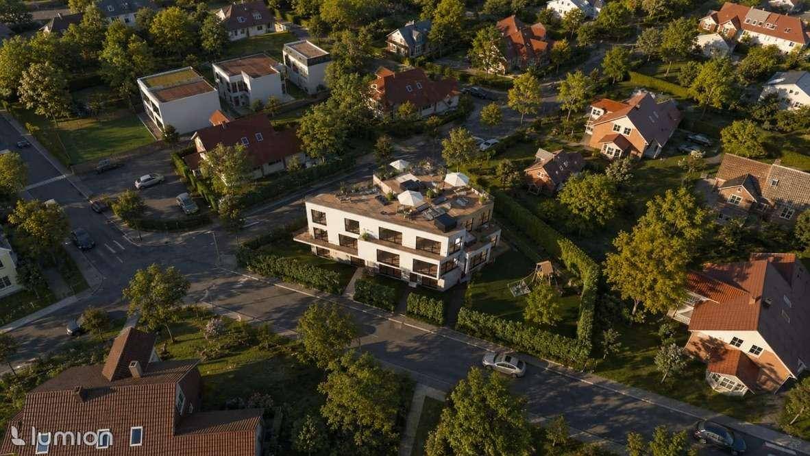 Luftaufnahme der modernen Wohnanlage in einer grünen Wohngegend mit umliegenden Häusern.