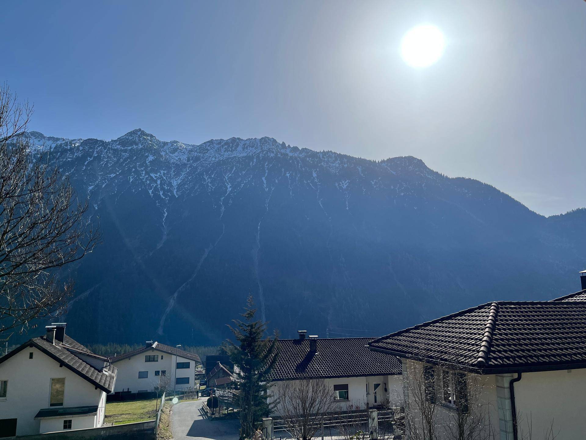 Weitblick auf die majestätische Bergkette und die umliegende Wohngegend unter blauem Himmel.