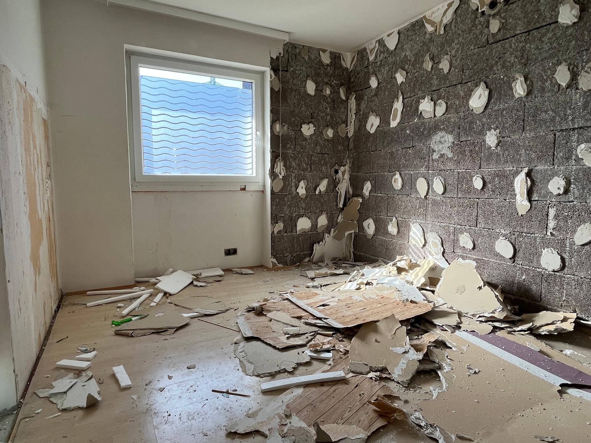 Schlafzimmer in Renovierung mit freiliegender Ziegelwand und Fenster, bereit für neue Gestaltung.