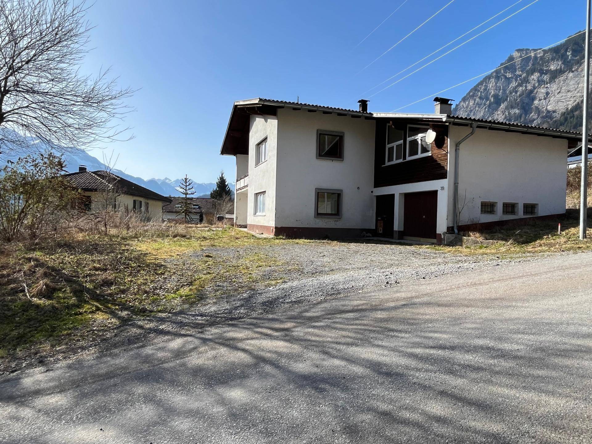 Freistehendes Haus mit umliegendem Grundstück und Bergblick in sonniger Lage.