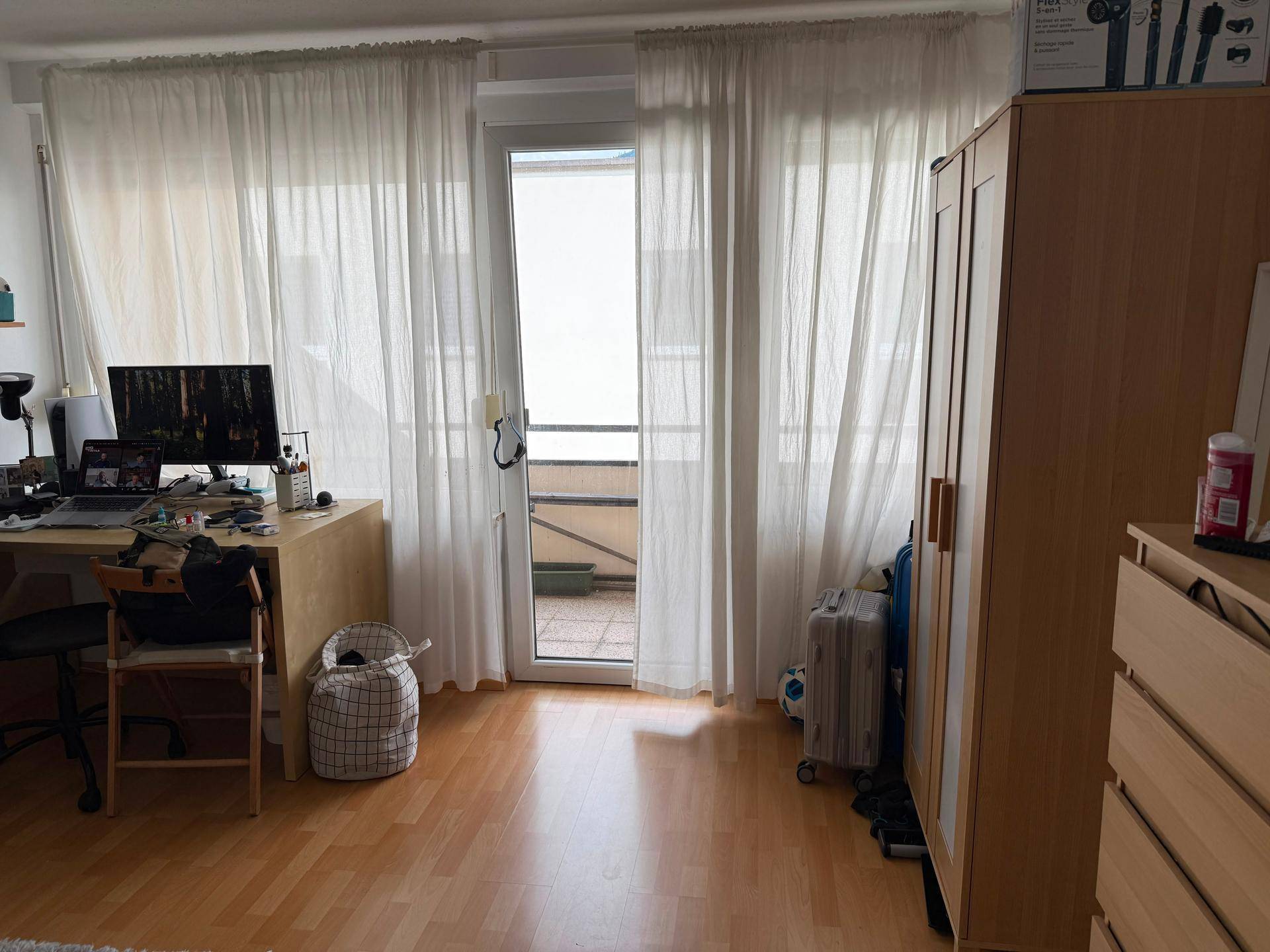 Lichtdurchflutetes Schlafzimmer mit Balkonzugang und hellen, transparenten Vorhängen für Privatsphäre.