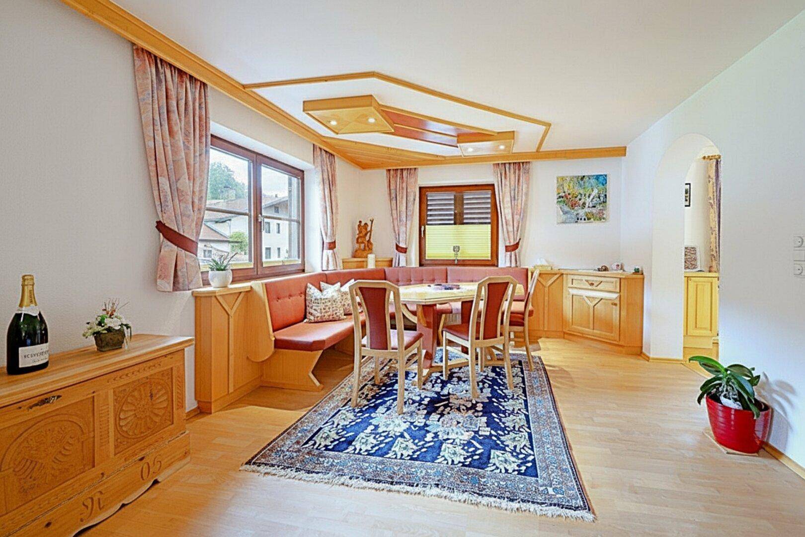 Gemütlicher Essbereich mit traditionellen Holzmöbeln, Eckbank und dekorativer Holzdecke.