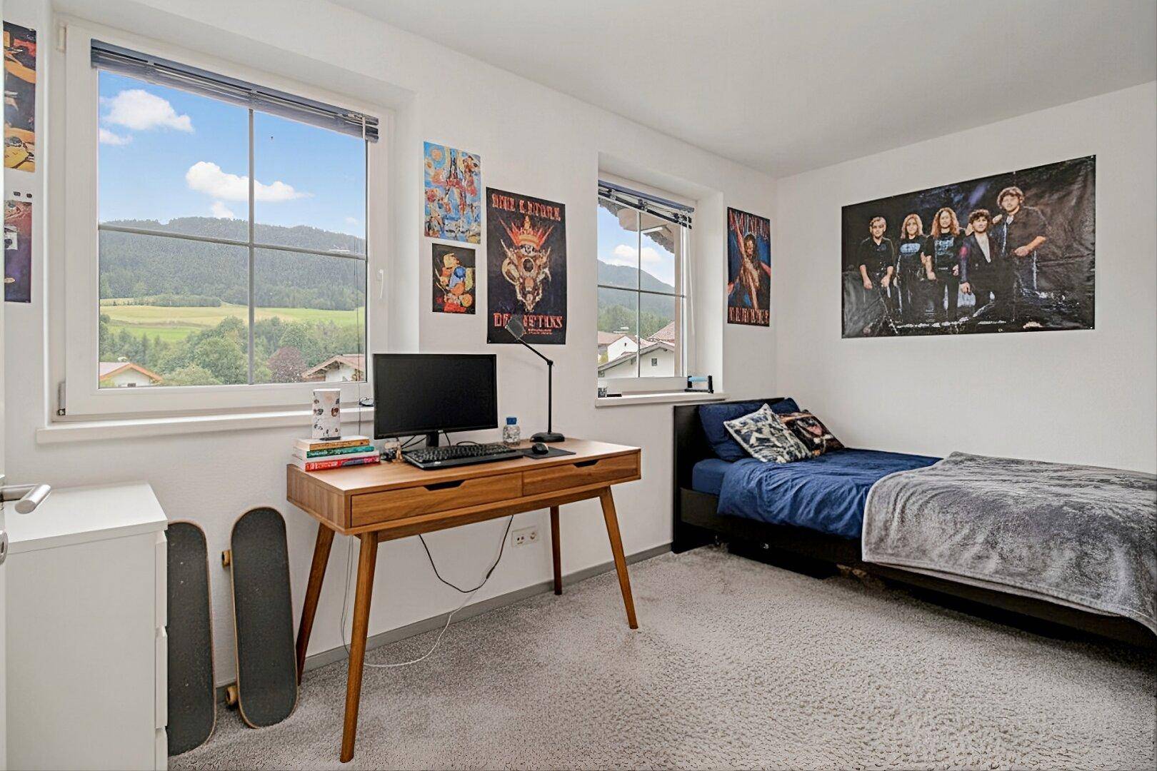 Jugendzimmer mit Schreibtisch, Einzelbett und weitem Blick auf die umliegende Landschaft.