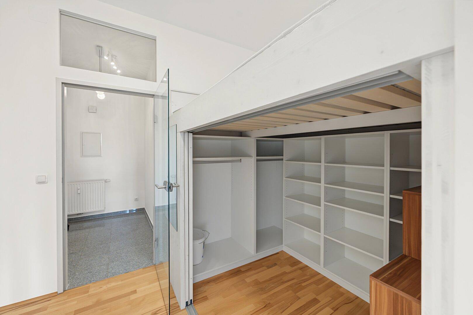 Schlafbereich mit Hochbett, Stauraum und Zugang zu einem weiteren Zimmer.