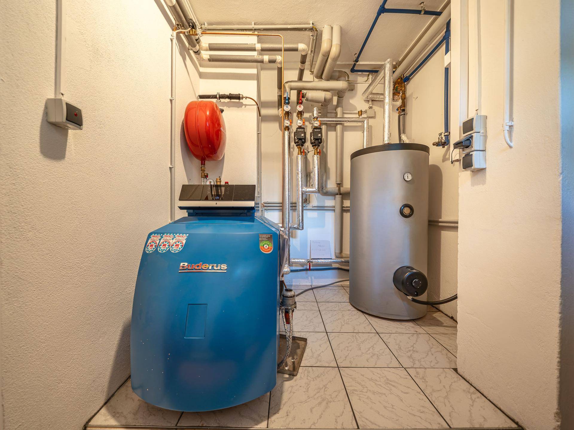 Heizungsraum mit Buderus-Heizkessel und Warmwasserspeicher, gut gewartet und funktionsfähig.