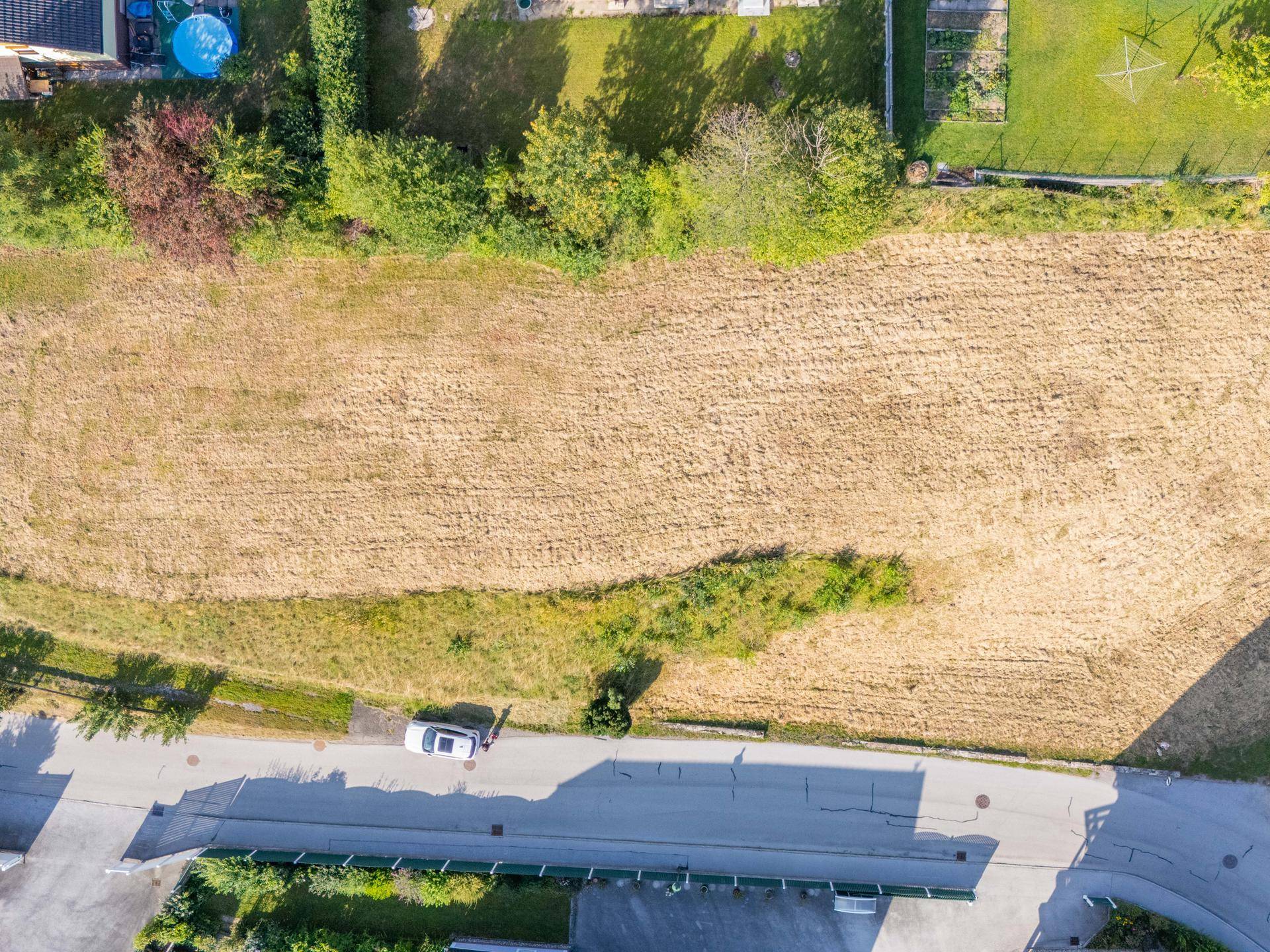 Übersicht des weitläufigen Grundstücks von oben, mit angrenzender Straße und umliegenden Gärten.