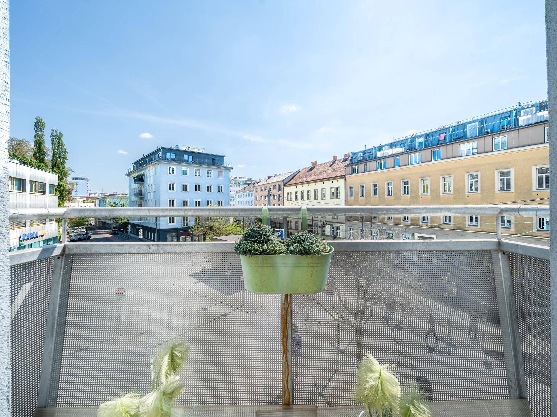 Balkon mit Metallgeländer und Blick auf die umliegenden Gebäude.