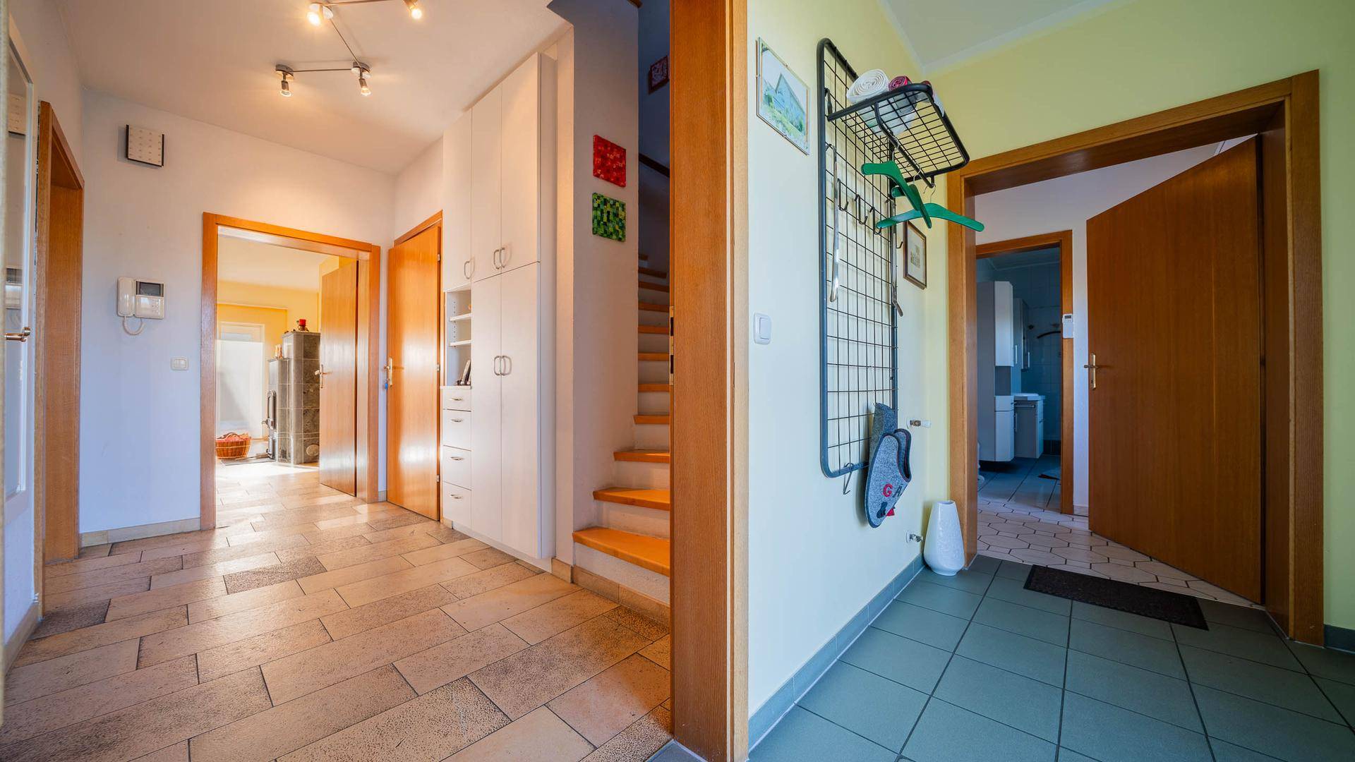 Eingangsbereich mit Fliesenboden, Garderobe und Zugang zu verschiedenen Räumen.