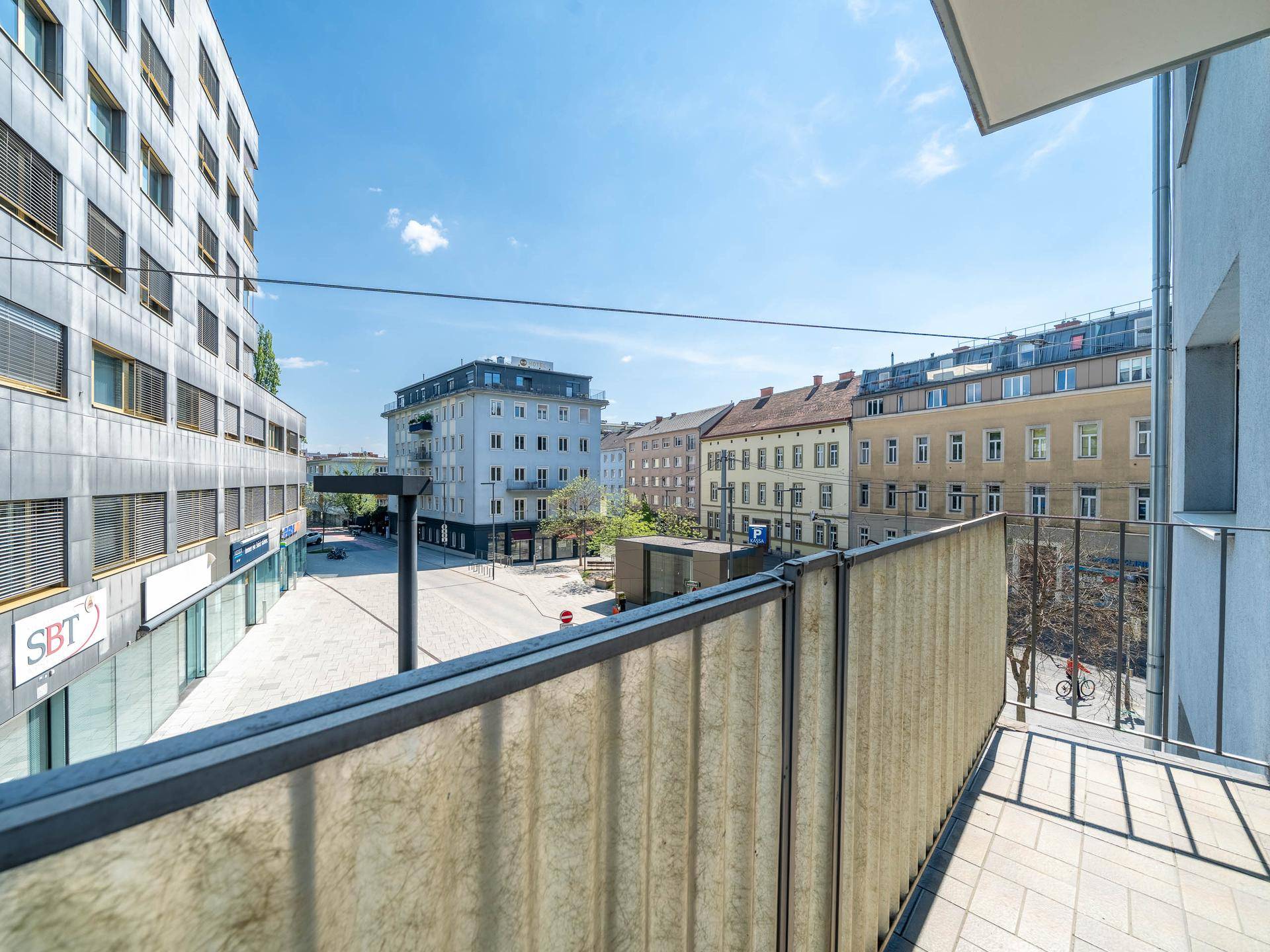 Blick vom Balkon auf die umliegende Stadtbebauung und Straße.