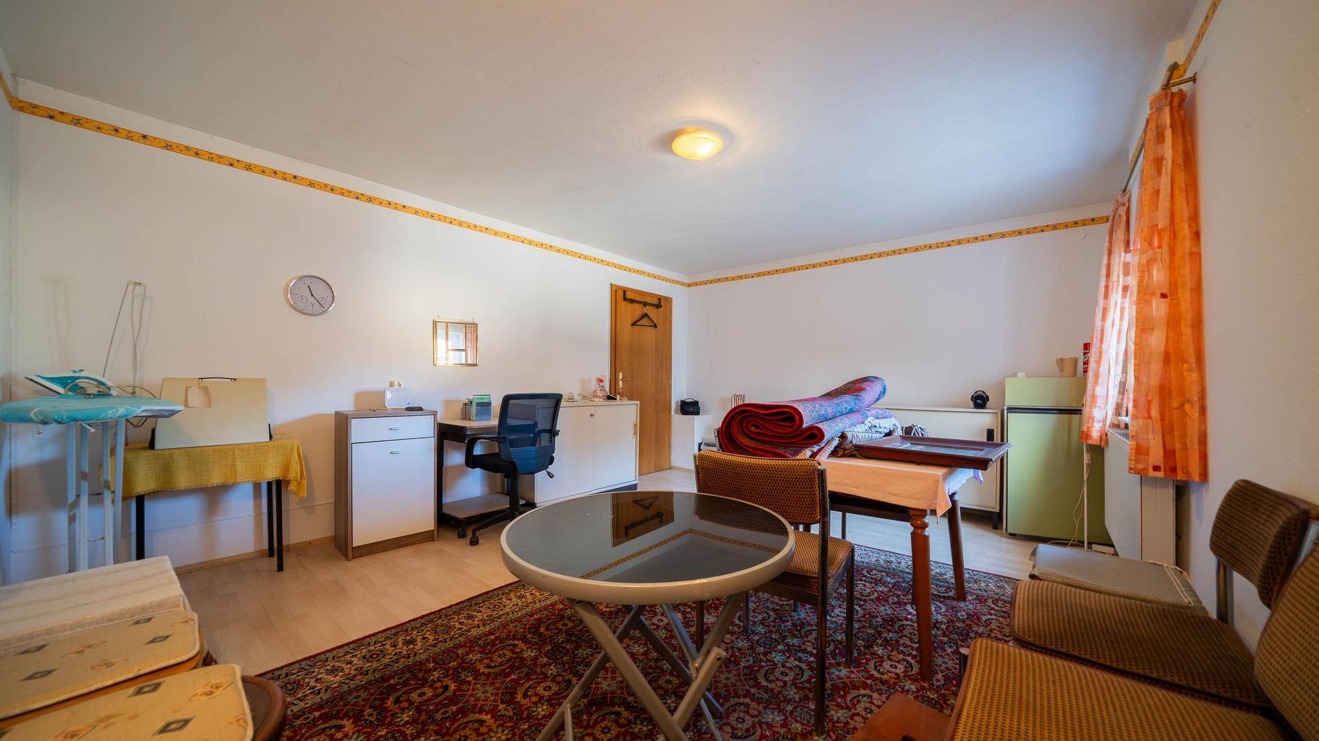 Geräumiger Raum mit Tisch, Stühlen und Fenster, ideal für verschiedene Aktivitäten.