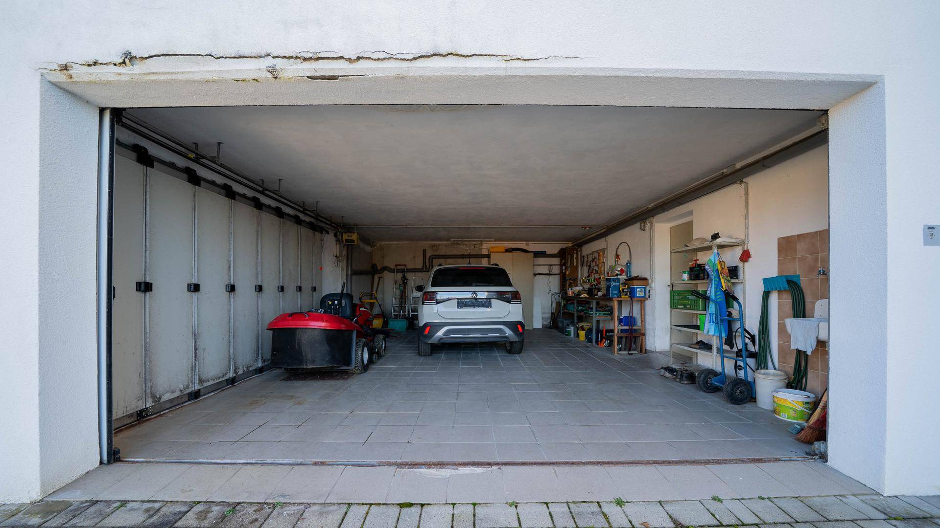 Geräumige Garage mit Platz für ein Auto und Abstellmöglichkeiten.