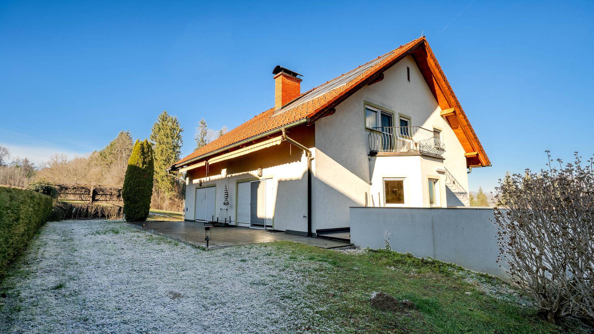 Haus mit Terrasse, Garten und Photovoltaikanlage auf dem Dach.