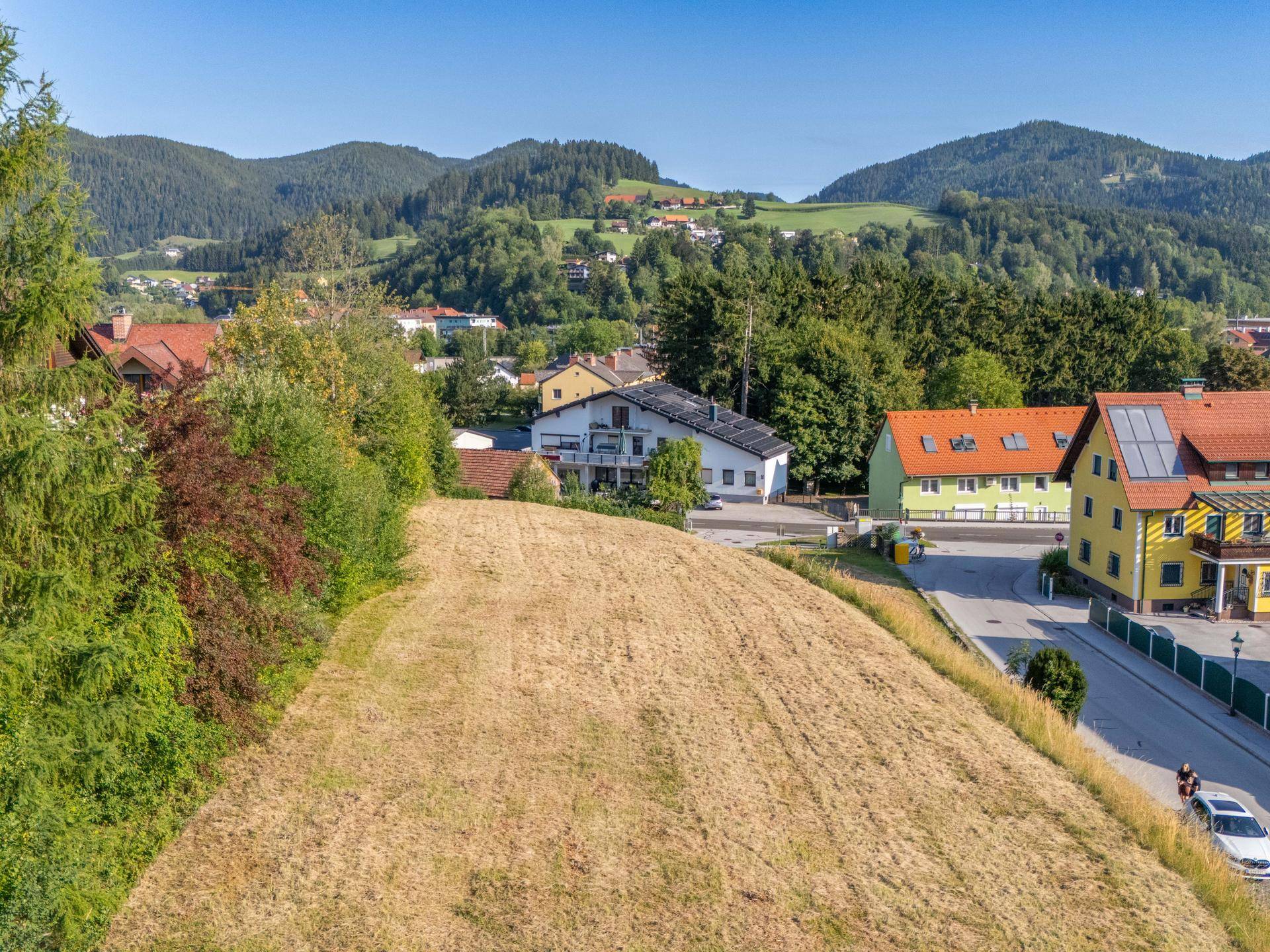 Attraktives Baugrundstück mit freiem Blick auf die bewaldeten Berge und die umliegende Wohngegend.
