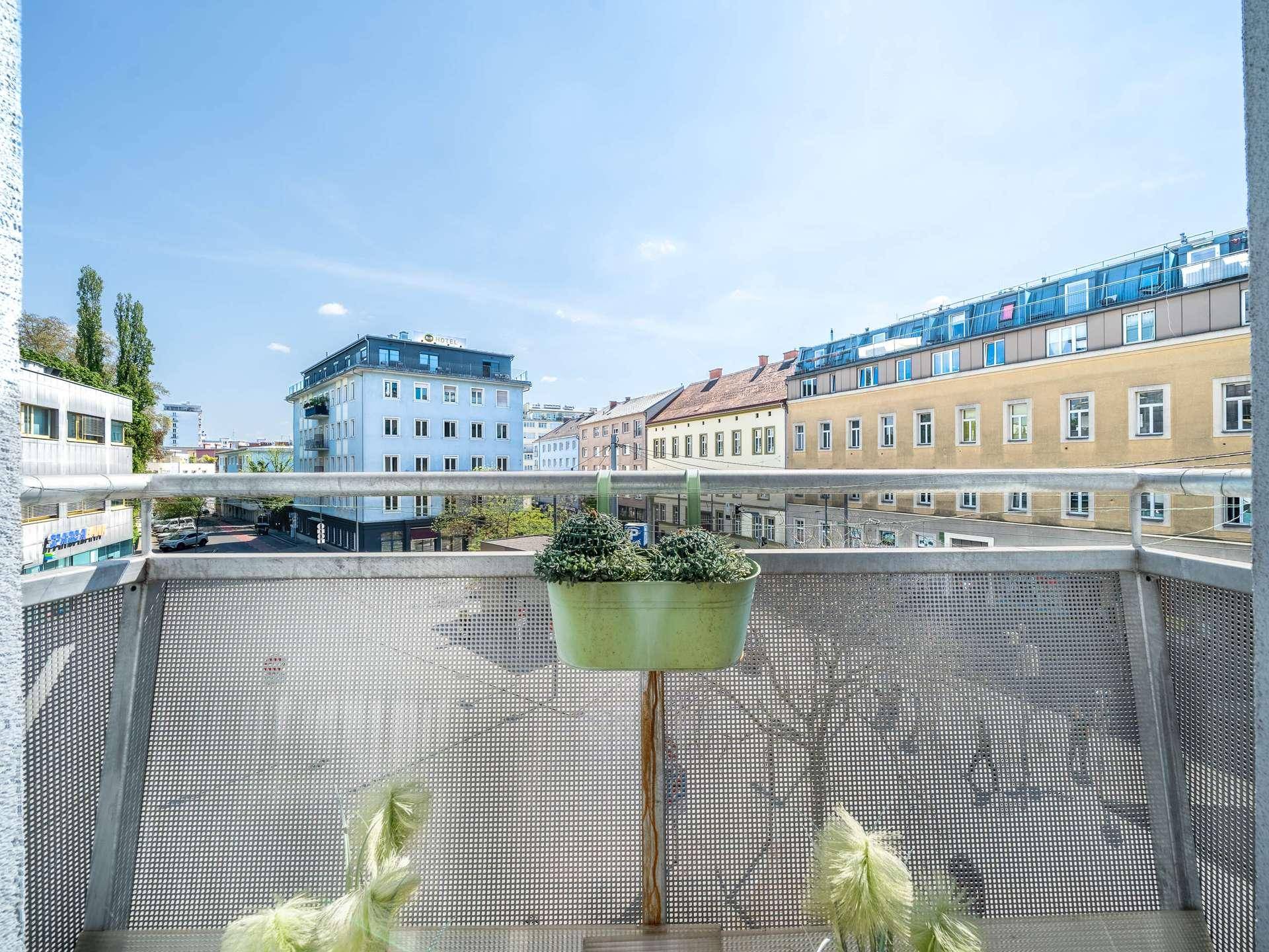 Balkon mit Blick auf die Stadt und den blauen Himmel.