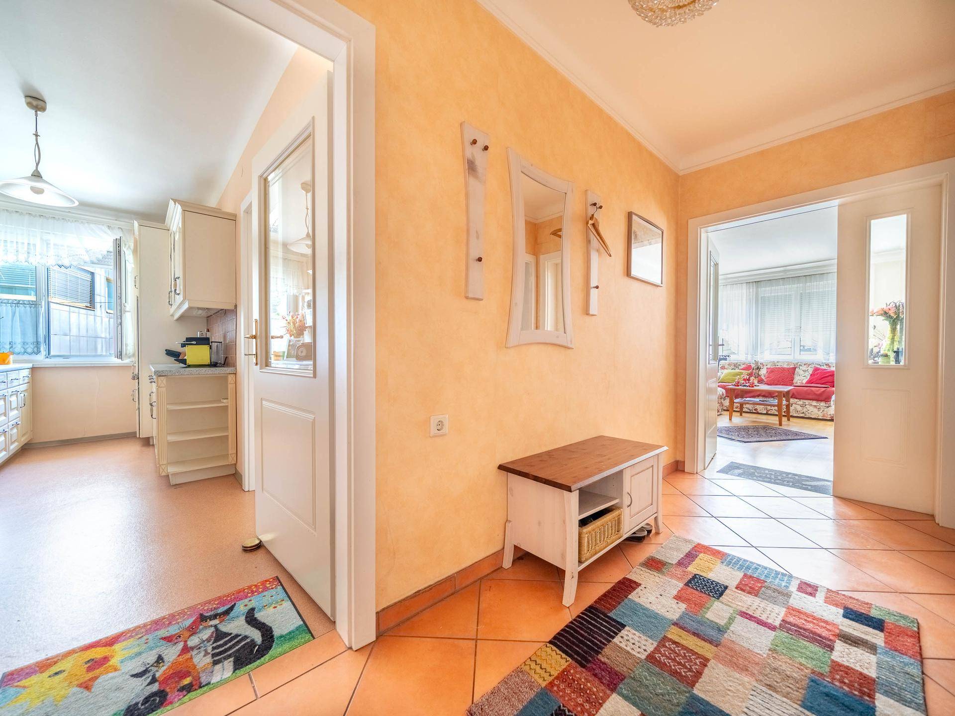 Flur mit Terrakottafliesen und Zugang zu Küche und Wohnzimmer.