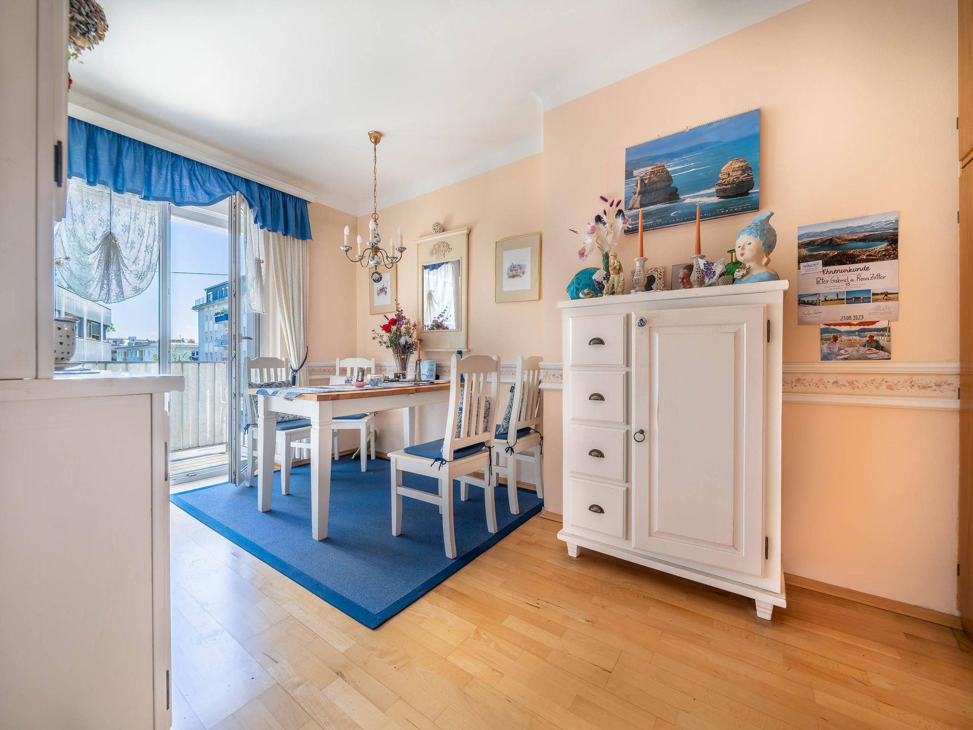 Heller Essbereich mit Holzboden, weißem Schrank und Zugang zum Balkon.