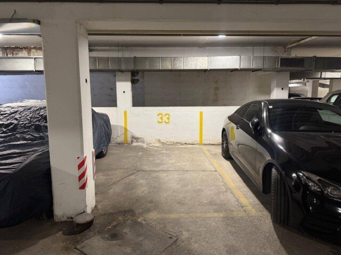 Einzelner, nummerierter Stellplatz 33 in einer sauberen und gut organisierten Tiefgarage.