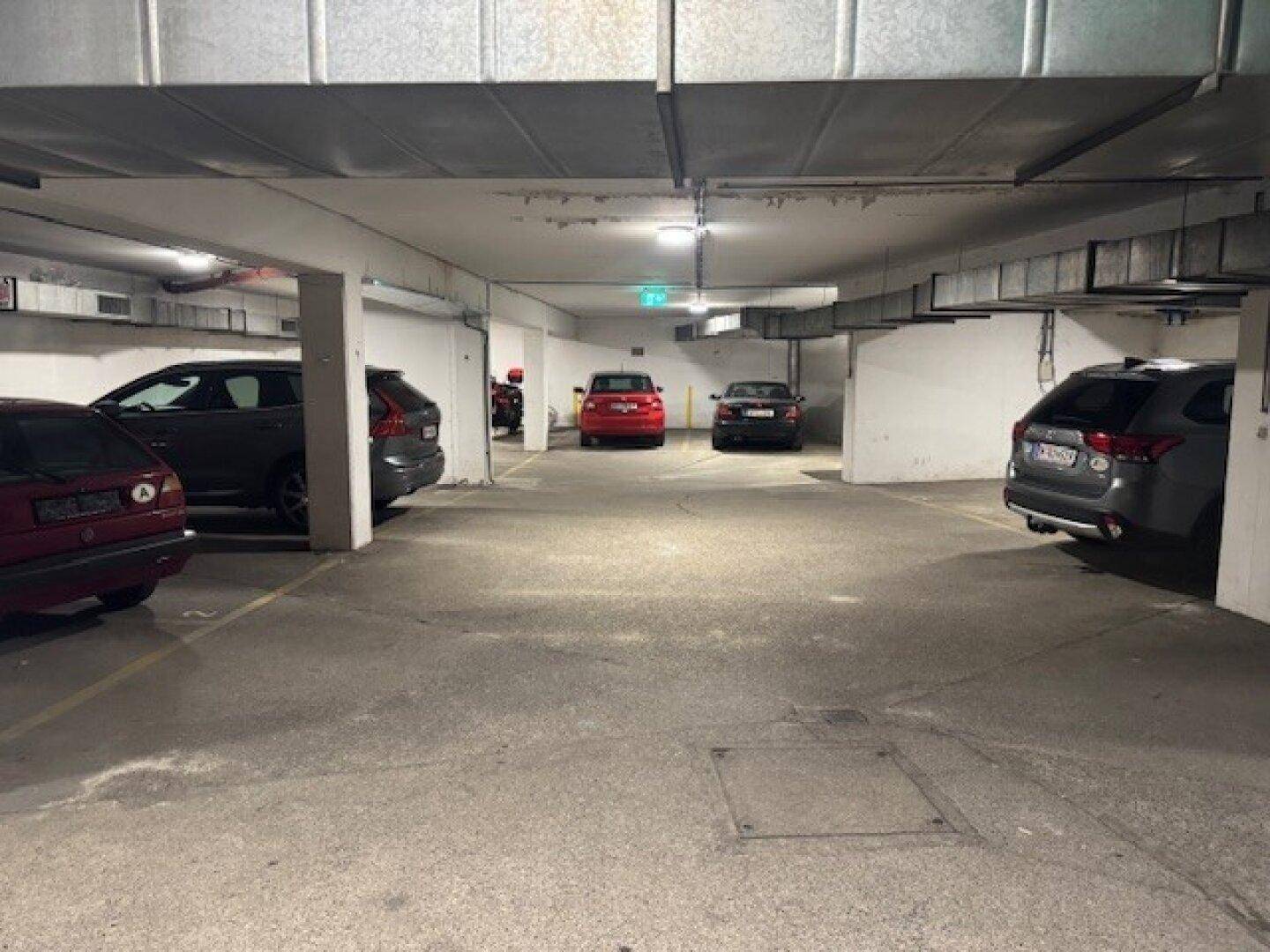 Geräumige Tiefgarage mit markierten Stellplätzen und effizienter Beleuchtung.