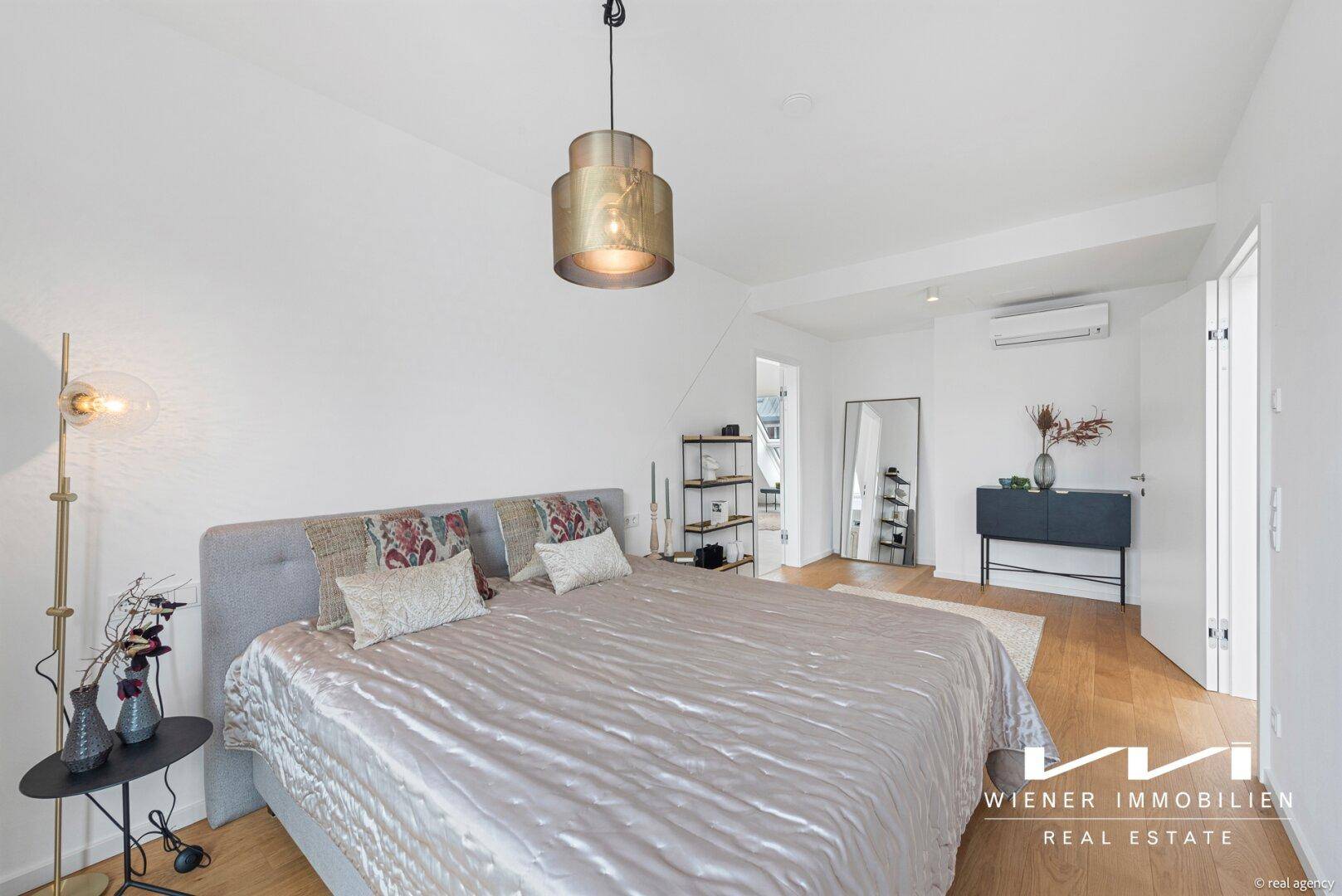 Modernes Schlafzimmer mit Holzboden, Klimaanlage und stilvoller Beleuchtung.