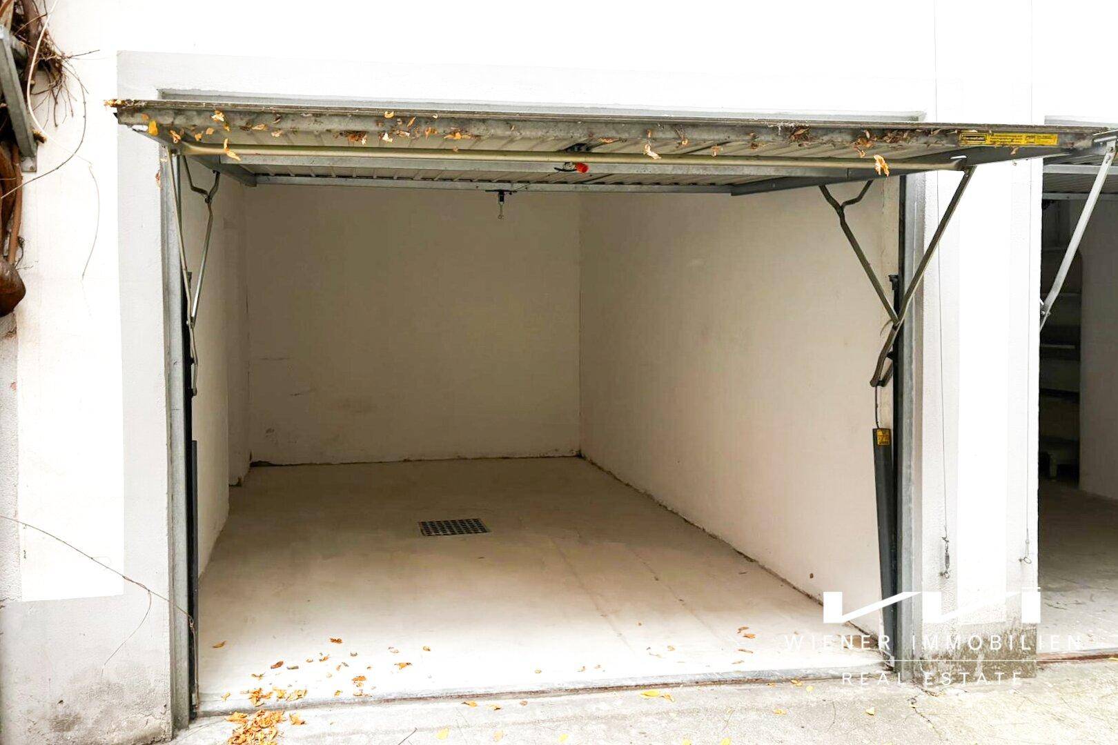 Leere Garage mit weißen Wänden und einem sauberen Betonboden, bereit zur Nutzung oder Lagerung.