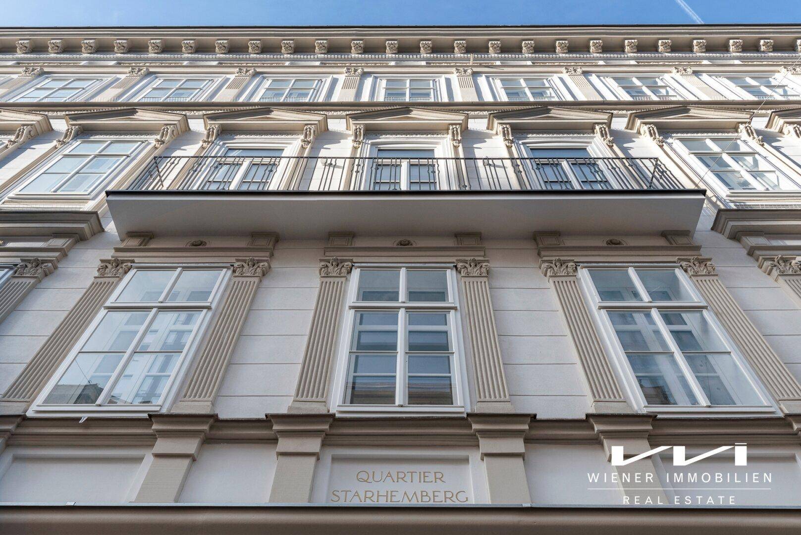 Historische Fassade eines Altbaus mit aufwendigen Verzierungen und einem französischen Balkon.
