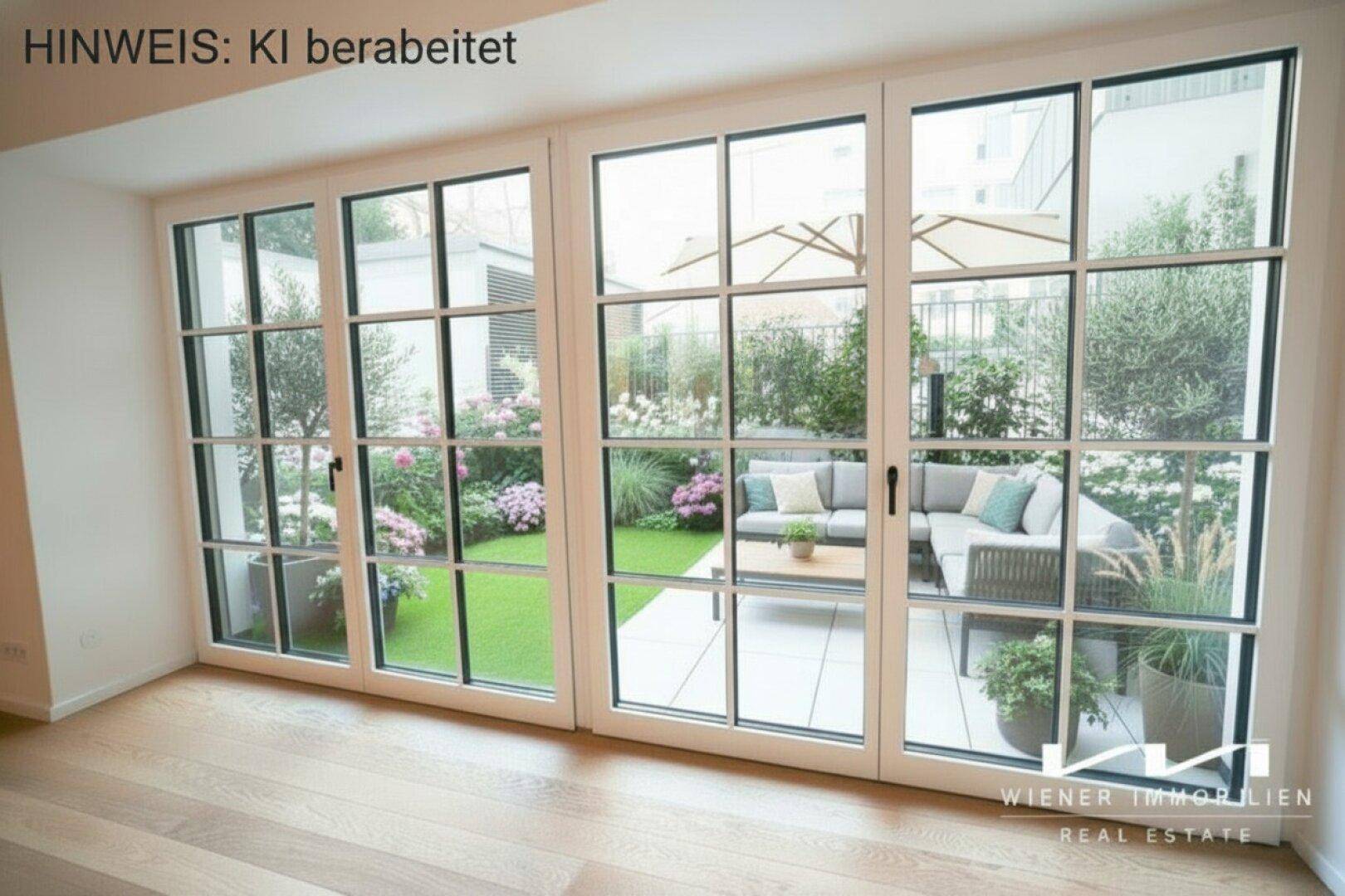 Blick aus dem Innenraum auf einen gepflegten Garten mit Sitzbereich und Sonnenschirm.