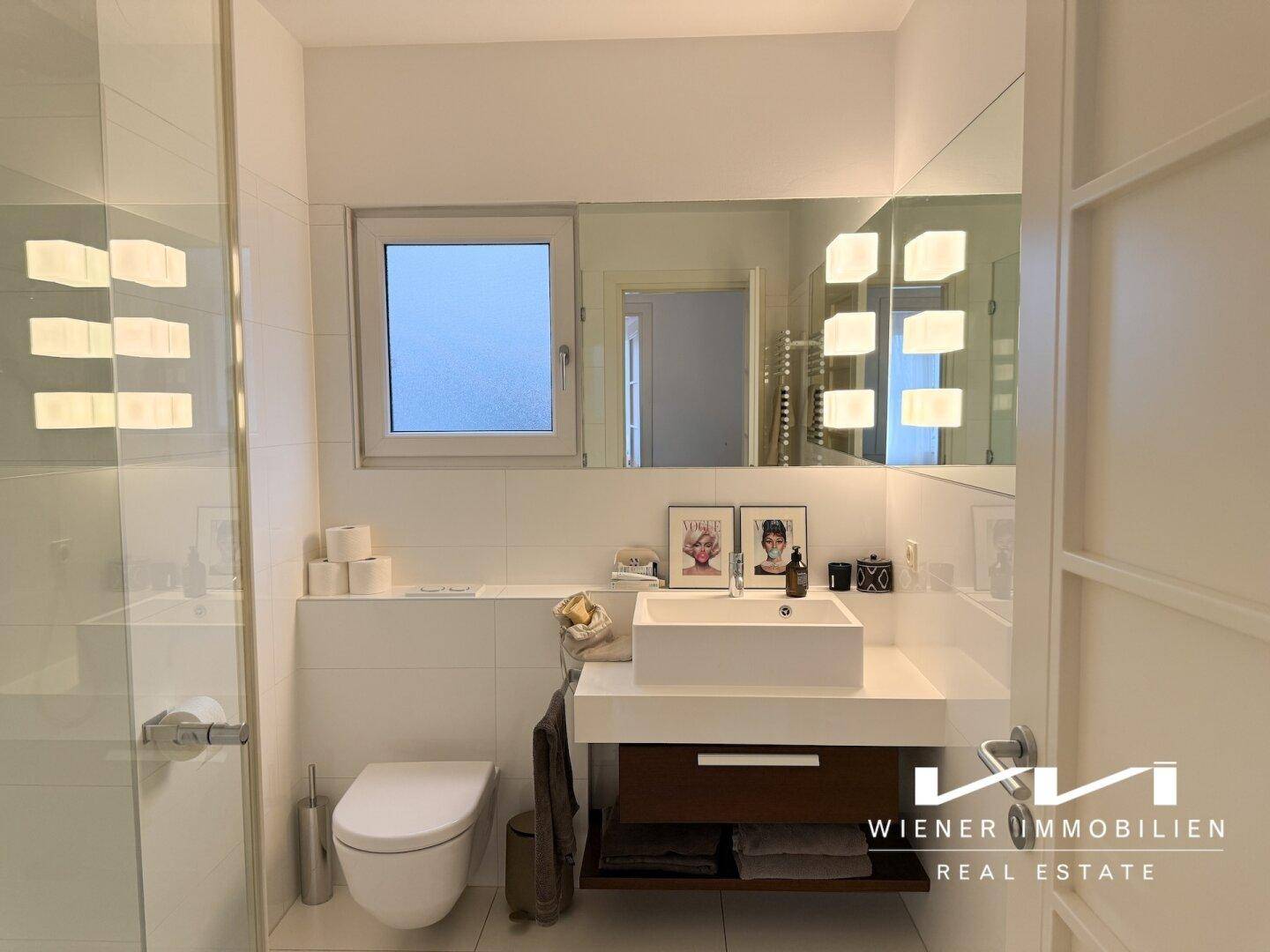 Modernes Badezimmer mit Toilette, Einzelwaschbecken und Duschkabine.