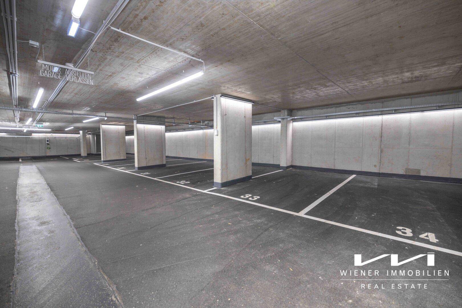 Weitläufige Tiefgarage mit zahlreichen markierten Stellplätzen und sichtbaren Betonpfeilern.
