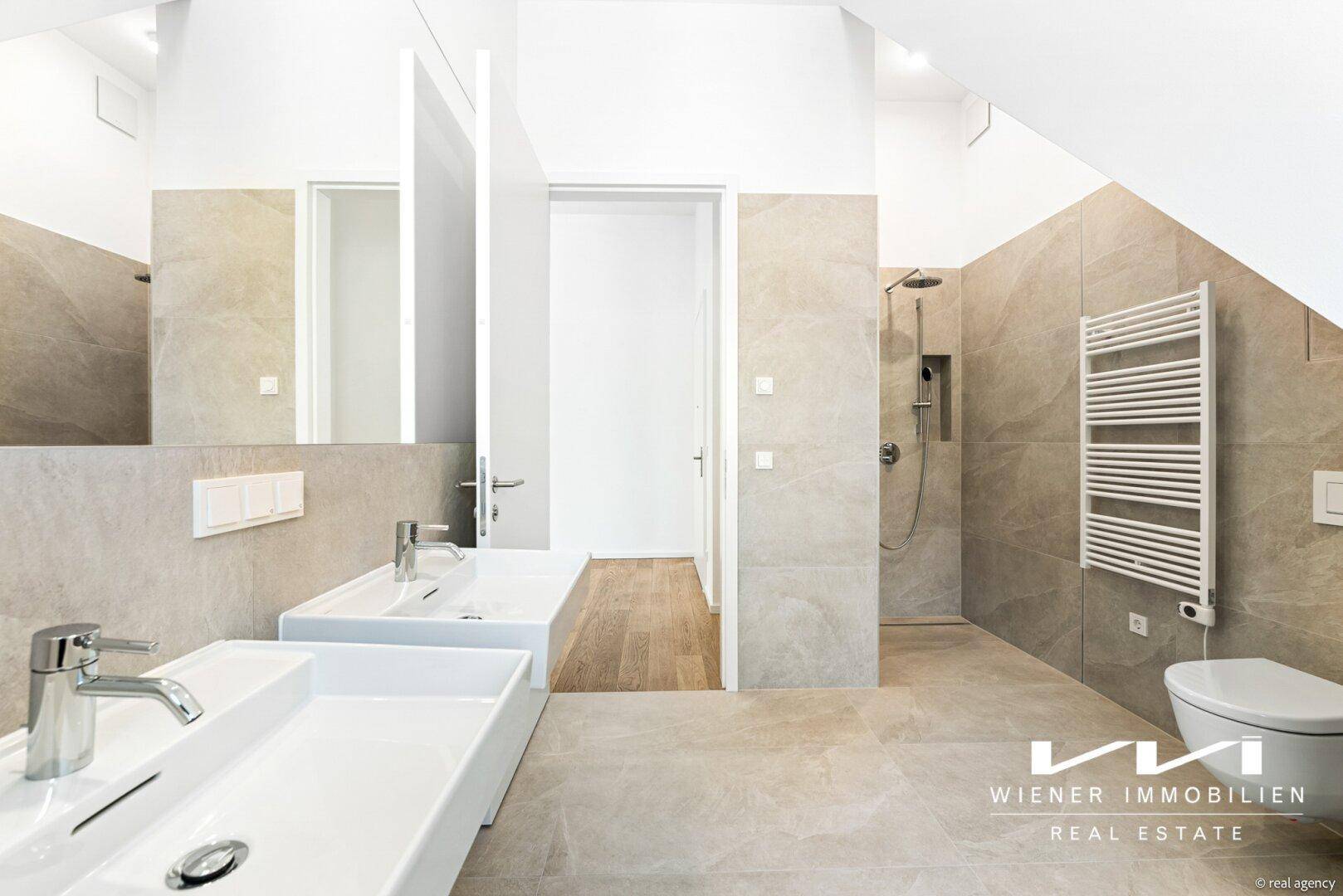 Modernes Badezimmer mit Doppelwaschbecken, begehbarer Dusche und beheiztem Handtuchhalter.