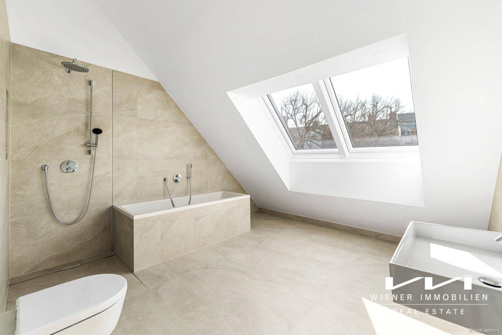Modernes Badezimmer mit Badewanne, Dusche, WC und großem Dachfenster.