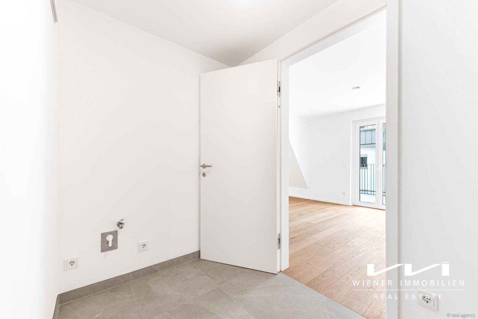Kleiner Hauswirtschaftsraum mit Fliesenboden und Anschlüssen, angrenzend an den Wohnbereich.