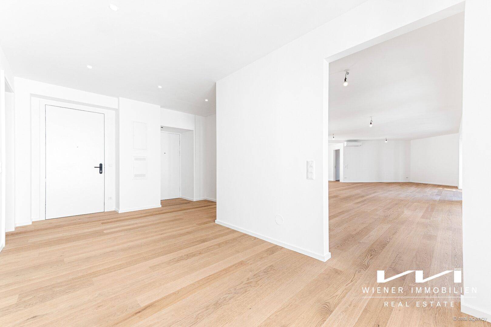 Heller Eingangsbereich mit Eichenparkett und offenem Übergang zu den weiteren Wohnbereichen.