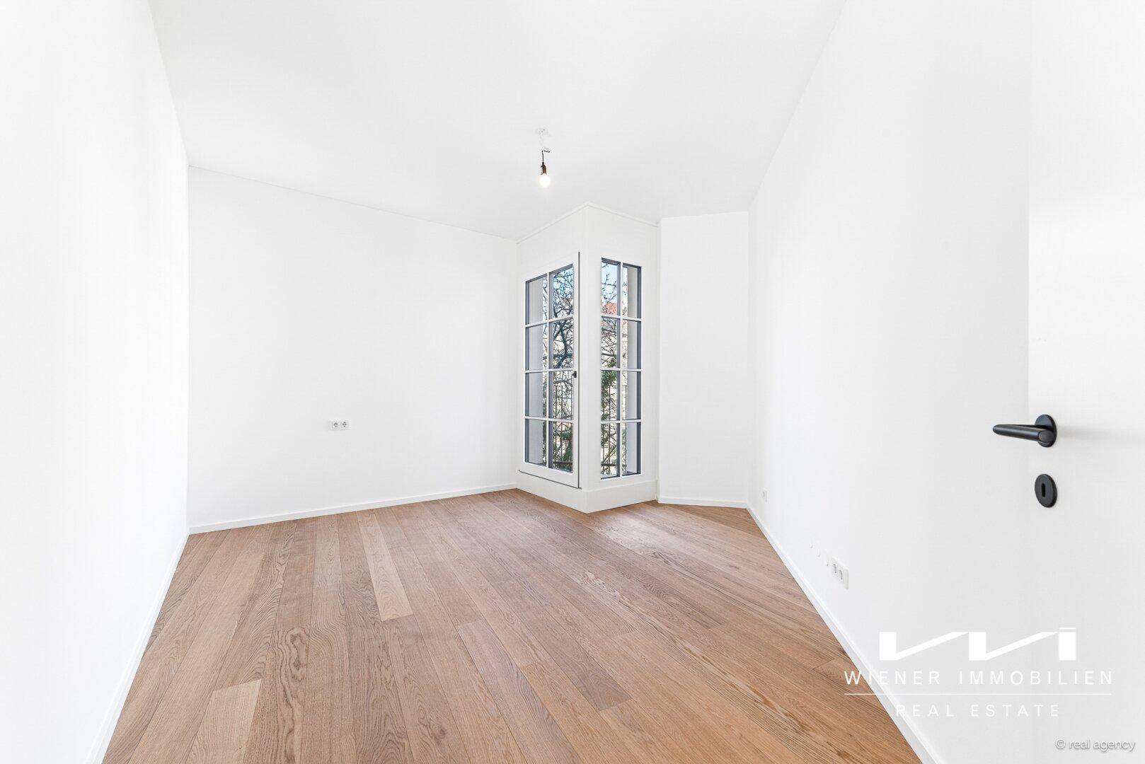 Helles Zimmer mit Eichenparkett und einem charmanten Erkerfenster, ideal als Schlaf- oder Arbeitszimmer.