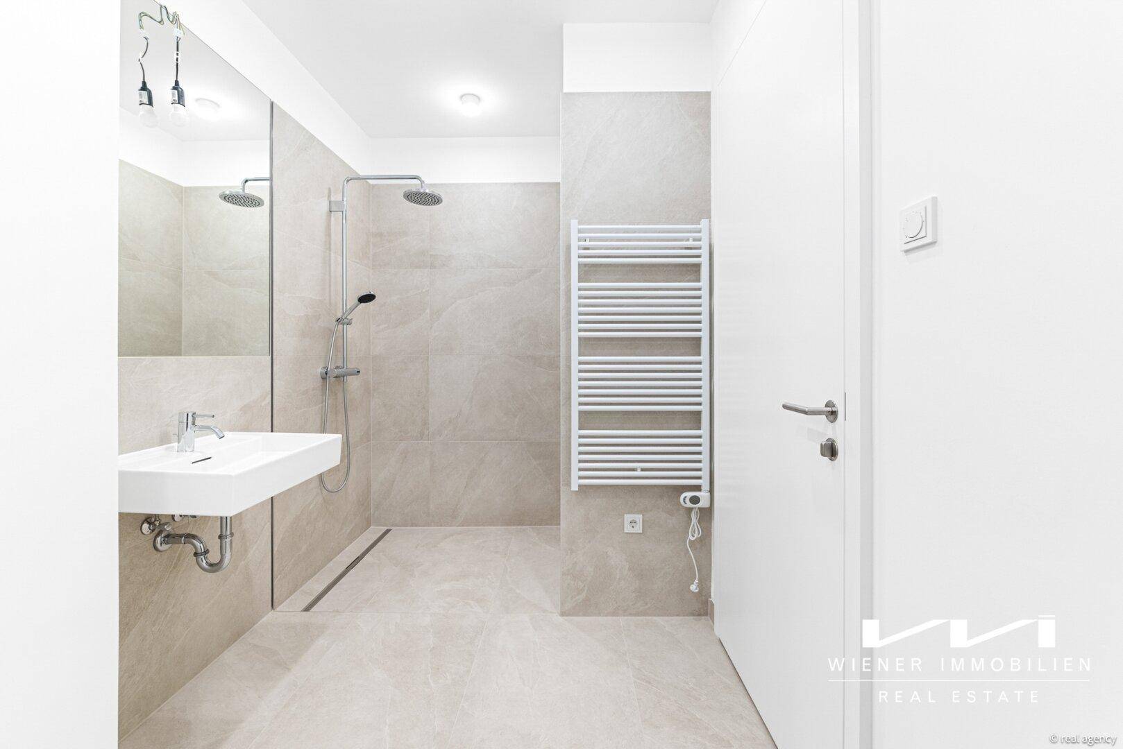 Modernes Badezimmer mit begehbarer Dusche, Wandfliesen und beheiztem Handtuchhalter.