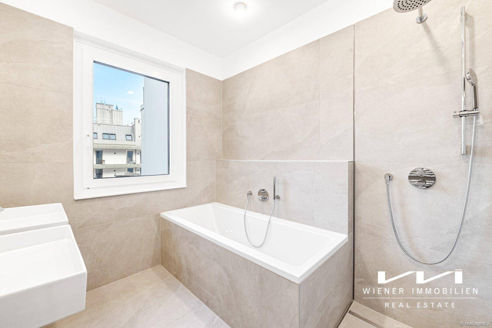 Modernes Badezimmer mit Badewanne, Dusche und großem Fenster für Tageslicht.