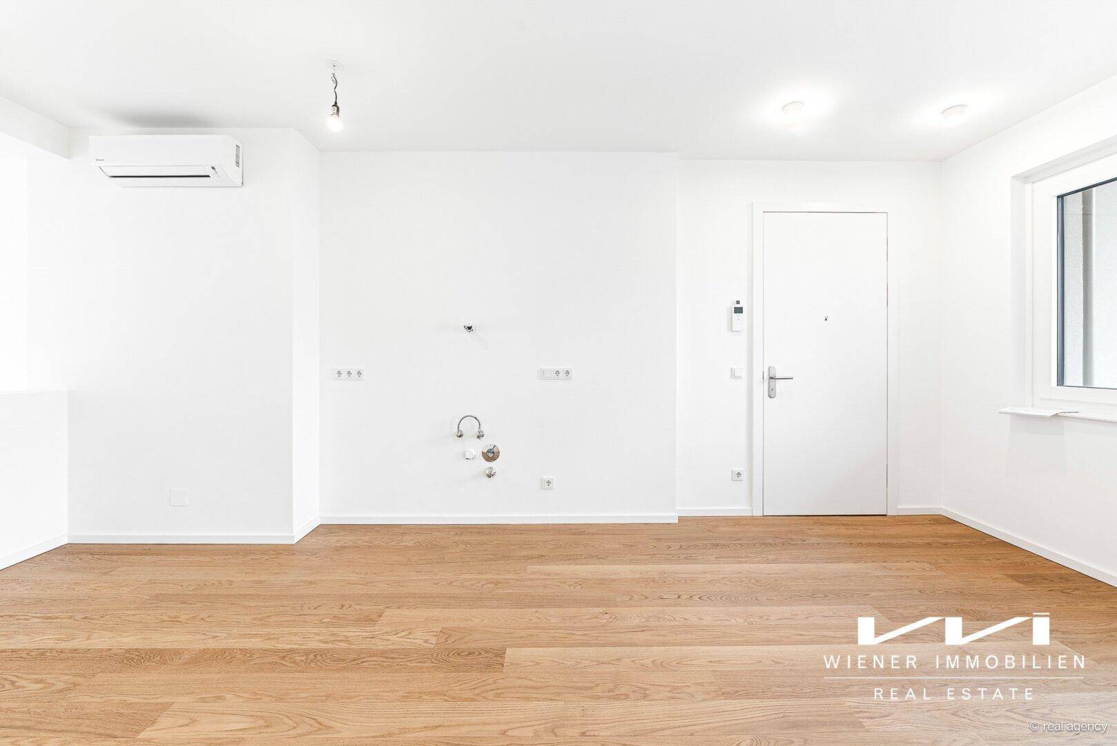 Heller Eingangsbereich oder Wohnraum mit Holzfußboden, Fenster und Klimaanlage.