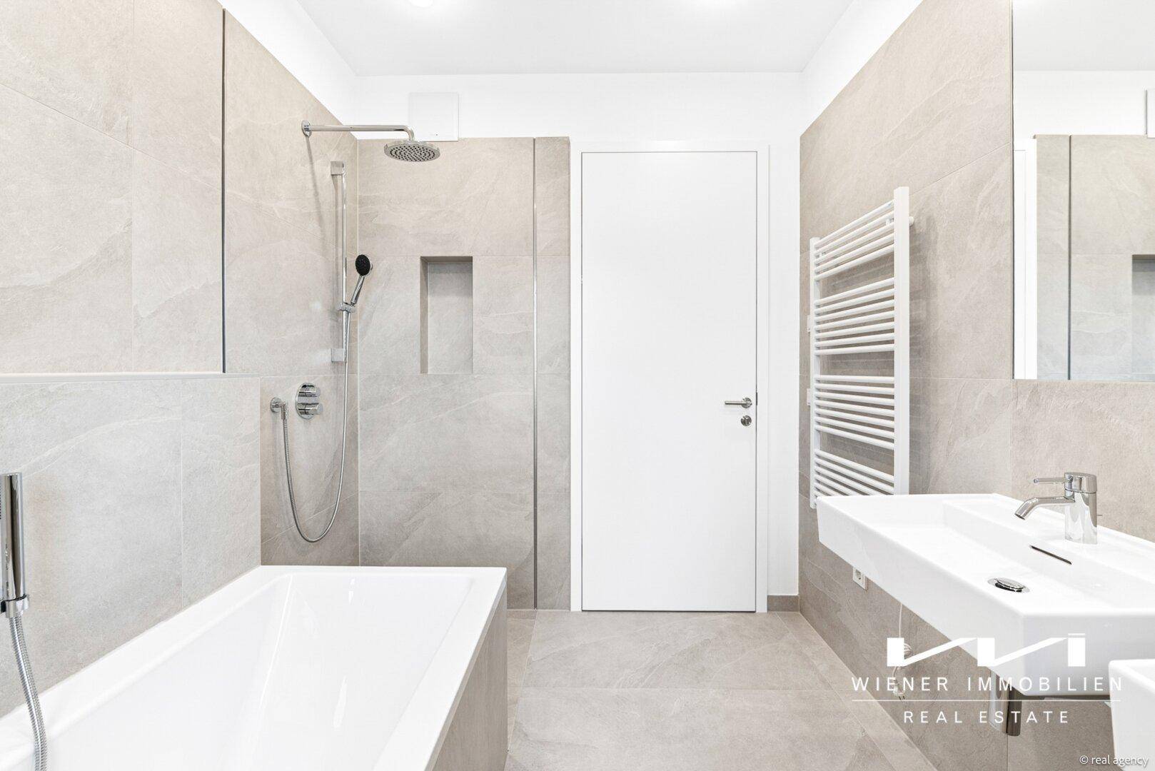 Modernes Badezimmer mit Dusche, Badewanne, Einzelwaschbecken und beheiztem Handtuchhalter.